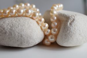 Piękne perły leżące na dwóch jasnych kamykach